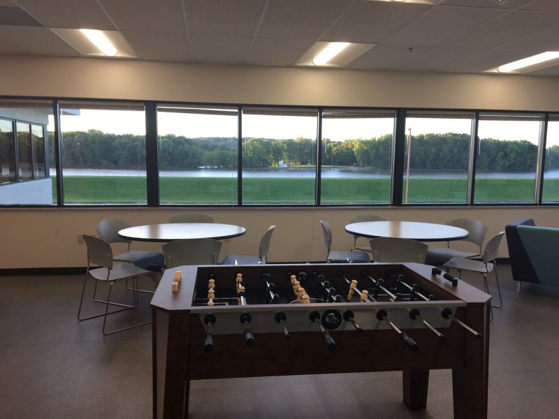 lunch room at American Customer Ccare with lunch tables and chairs and a Foosball table